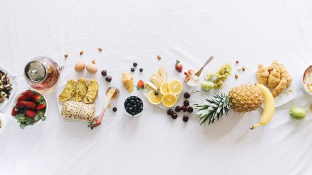 frutas y verduras lanzadas sobre un mesón blanco